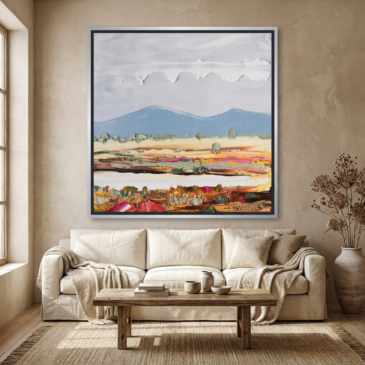 Oversized statement canvas wall art with a silver leaf surround styled in a neutral living room