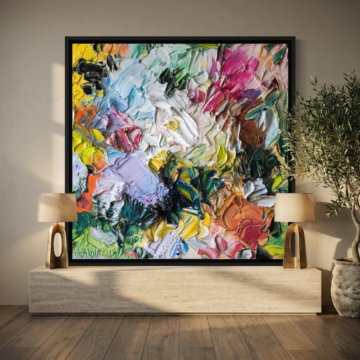 Canvas wall art with a black surround standing on a console in a luxe living room