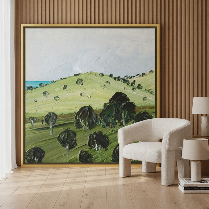 Oversized statement canvas wall art with a gold leaf surround leaning against the wall in a luxe bedroom