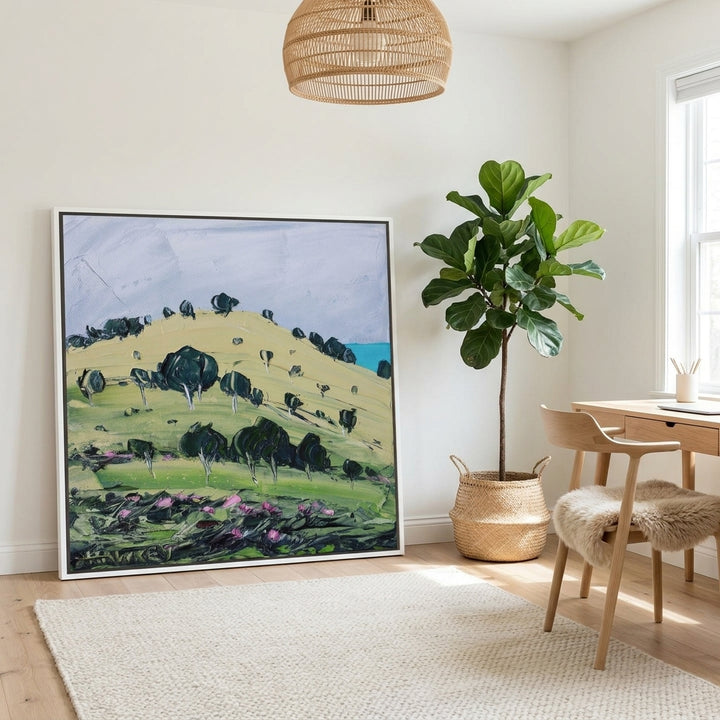 Canvas wall art with a white surround leaning against the wall in a bright Scandinavian home office