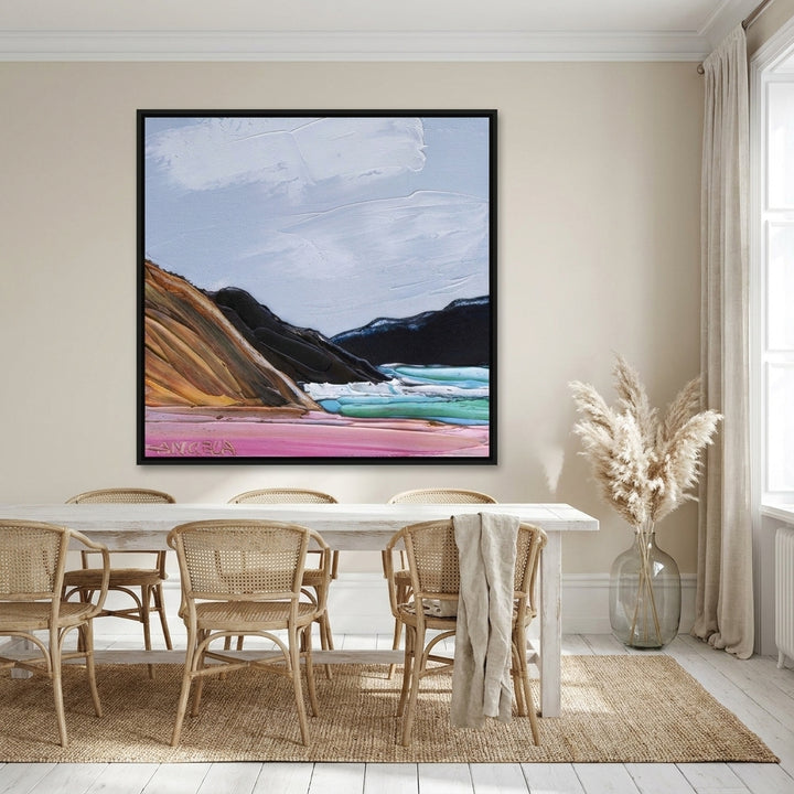 Oversized statement canvas wall art with a black surround styled on the wall in a coastal dining room