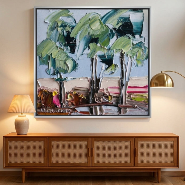 Oversized statement canvas wall art with a silver leaf surround styled on the wall in a mid-century living room