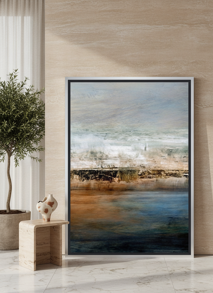 Oversized statement canvas wall art with a silver leaf surround leaning against the wall in a luxe living room