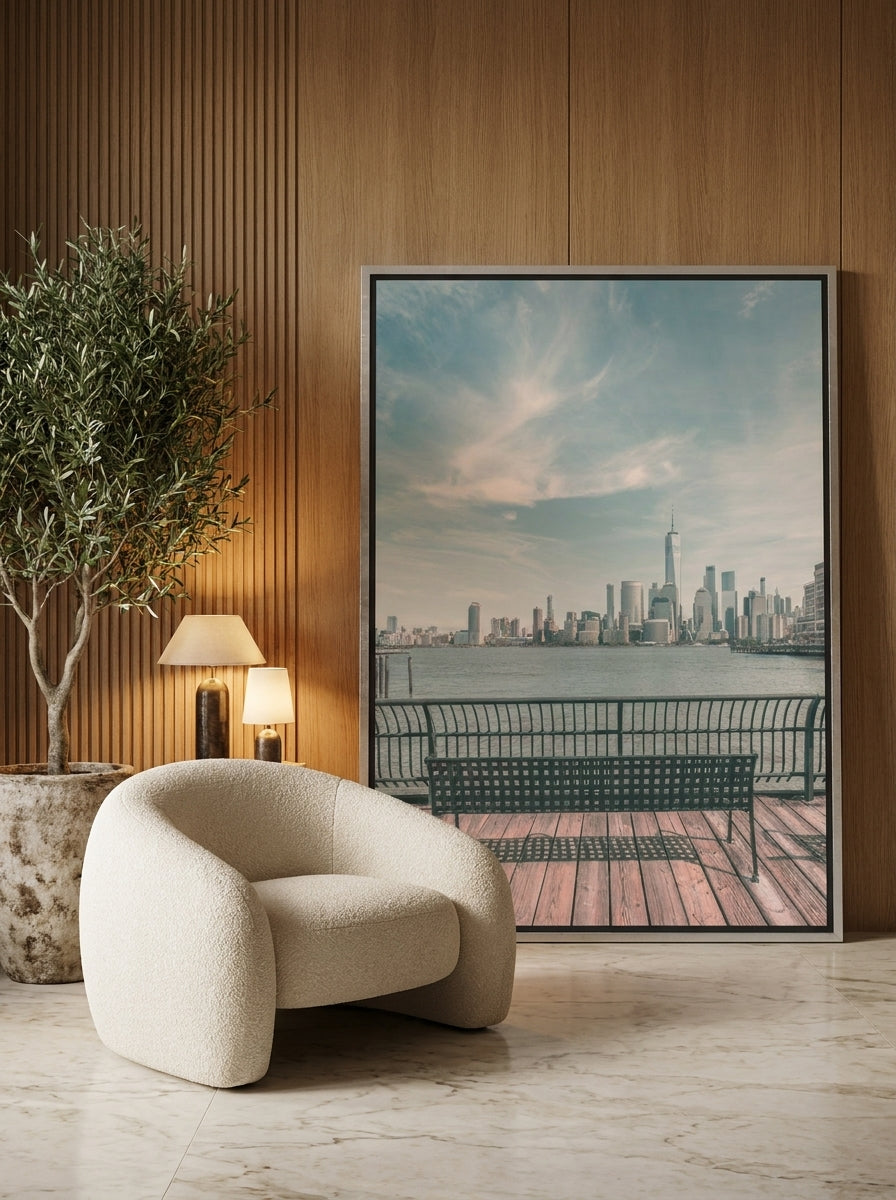 Oversized statement canvas wall art with a silver leaf surround leaning against the wall in a luxe living room
