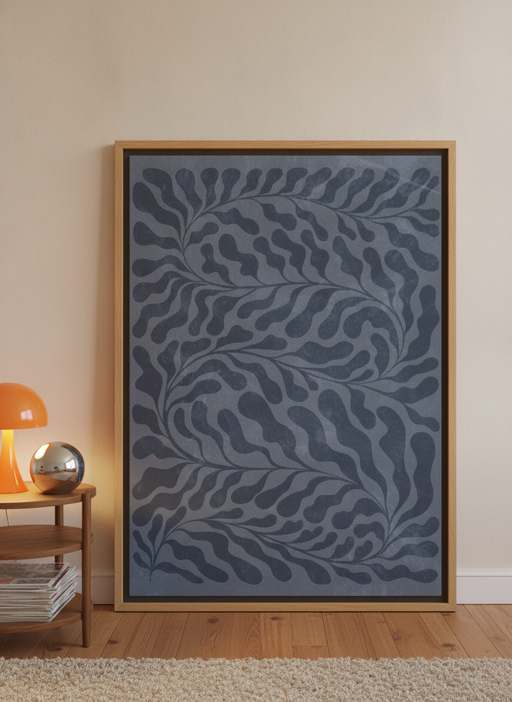 Oversized statement canvas wall art with a natural timber surround leaning against the wall in a retro 70s bedroom