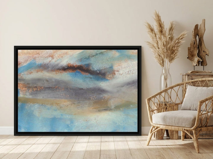 Oversized statement canvas wall art with a black surround leaning against the wall in a coastal dining room