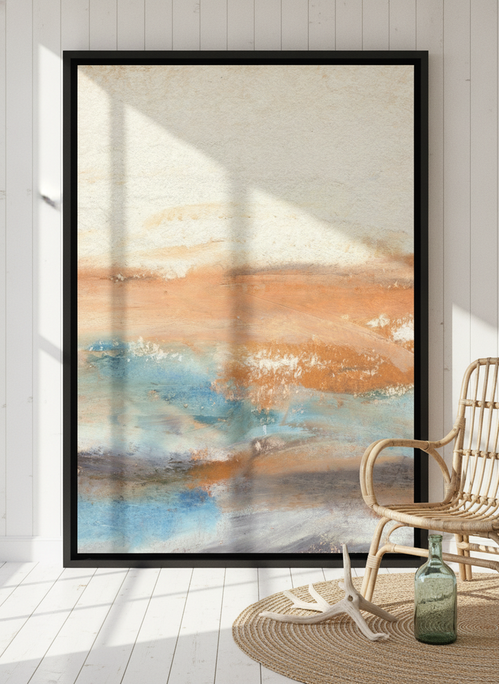 Oversized statement canvas wall art with a black surround leaning against the wall in a coastal bedroom
