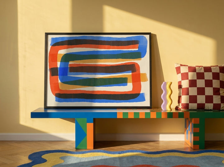 Modern wall art print standing on a side table in a colourful eclectic home office