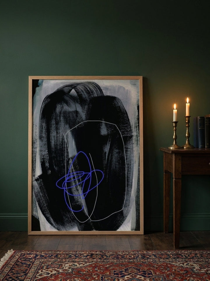 Modern wall art print leaning against the wall in a moody bedroom