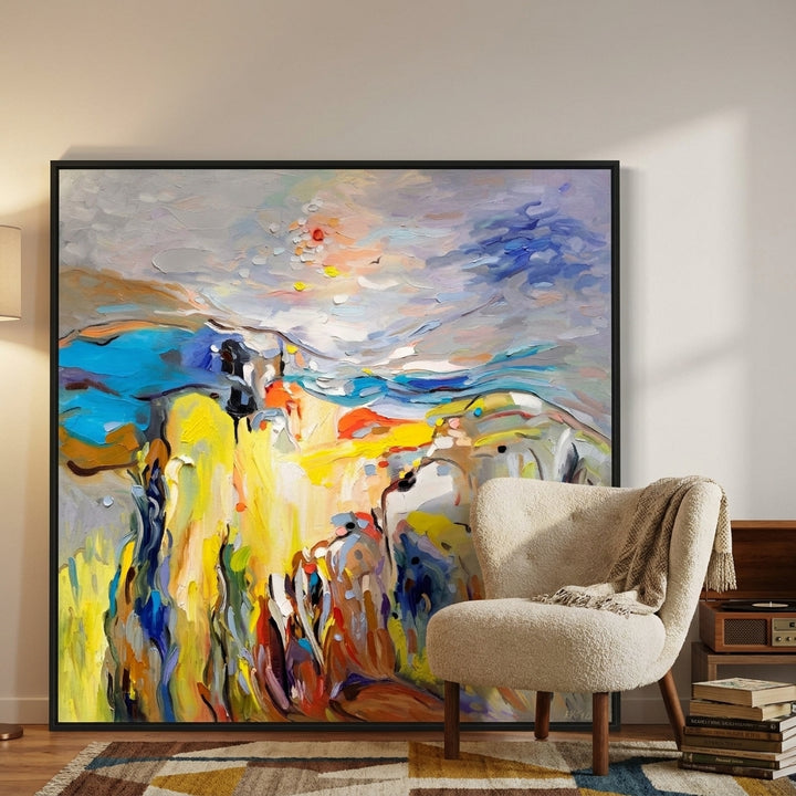 Oversized statement canvas wall art with a black surround leaning against the wall in a mid-century dining room