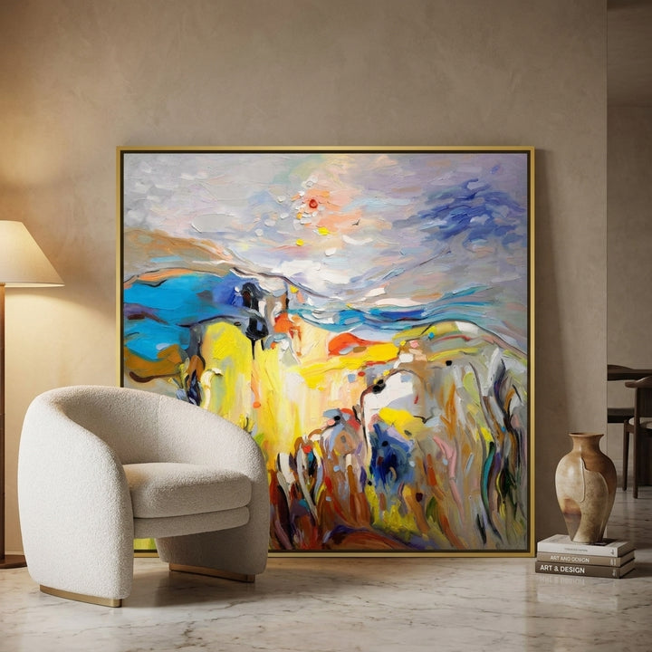 Oversized statement canvas wall art with a gold leaf surround leaning against the wall in a luxe dining room