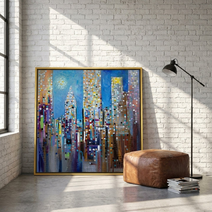 Oversized statement canvas wall art with a gold leaf surround leaning against the wall in an industrial loft dining room