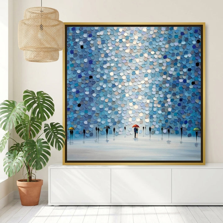 Canvas wall art with a gold leaf surround standing on a sideboard in a bright Scandinavian living room
