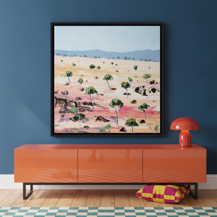 Canvas wall art with a black surround standing on a sideboard in a colourful eclectic home office