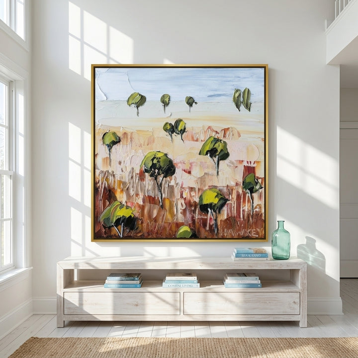 Oversized statement canvas wall art with a gold leaf surround styled on the wall in a coastal living room