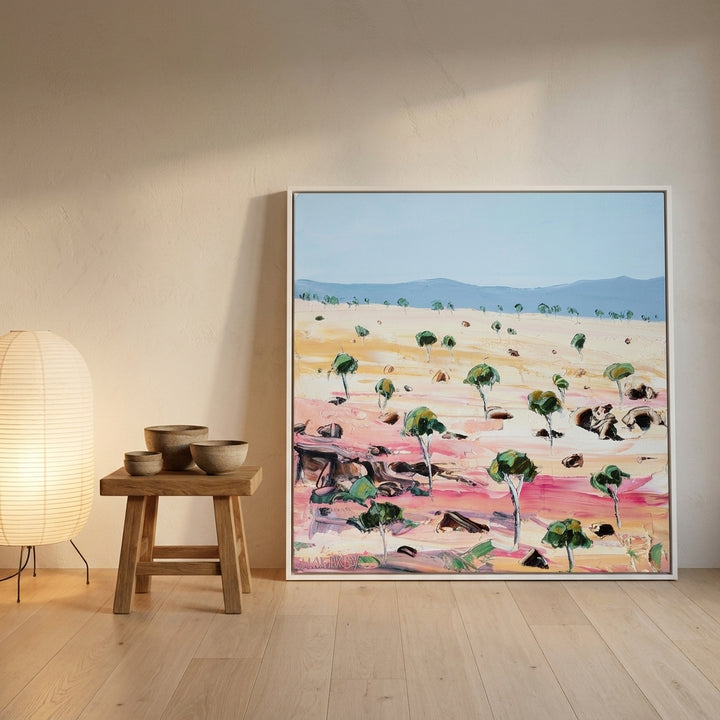 Canvas wall art with a white surround leaning against the wall in a warm Japandi bedroom