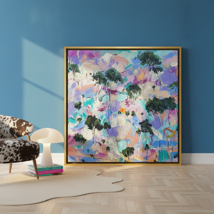 Oversized statement canvas wall art with a gold leaf surround leaning against the wall in a colourful eclectic living room