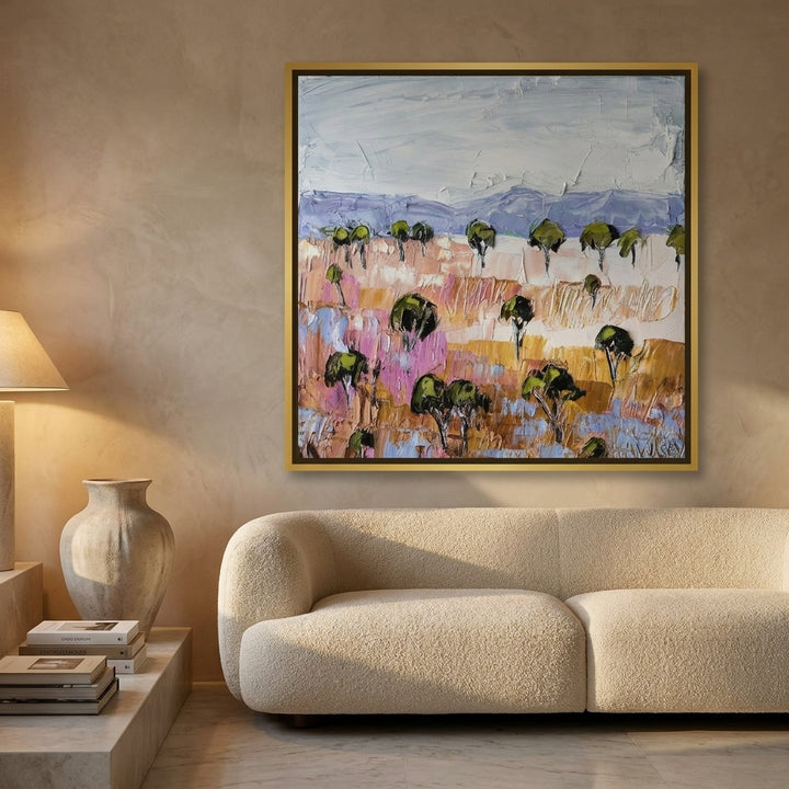 Oversized statement canvas wall art with a gold leaf surround styled on the wall in a luxe living room