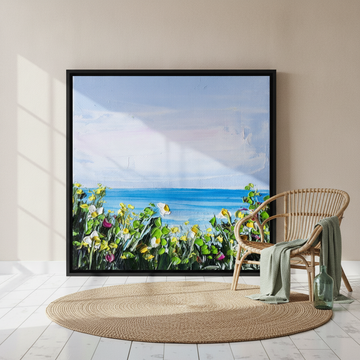 Oversized statement canvas wall art with a black surround leaning against the wall in a coastal living room