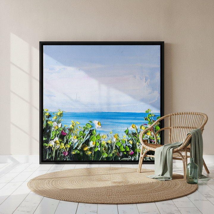 Oversized statement canvas wall art with a black surround leaning against the wall in a coastal living room