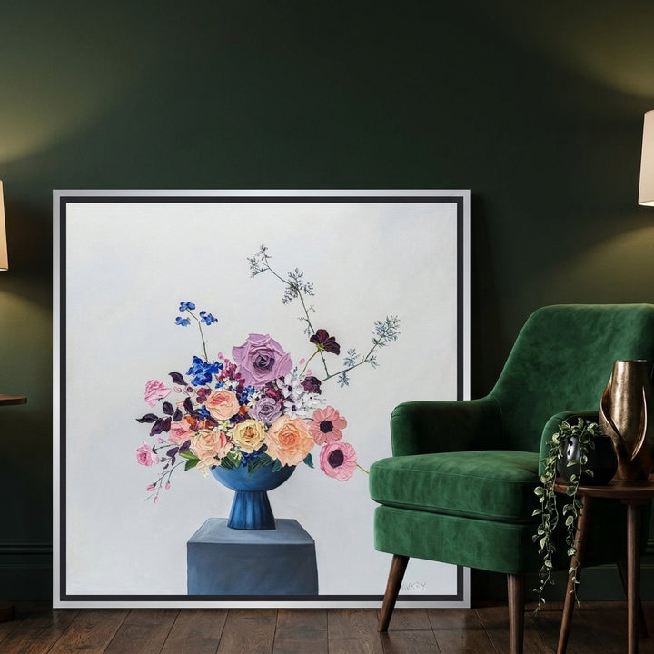 Canvas wall art with a silver leaf surround leaning against the wall in a moody living room