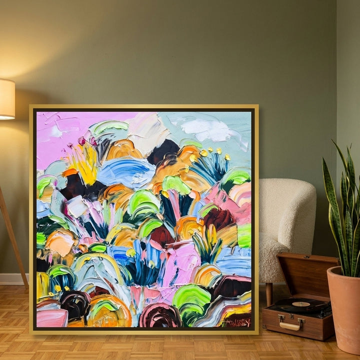 Canvas wall art with a gold leaf surround leaning against the wall in a mid-century home office