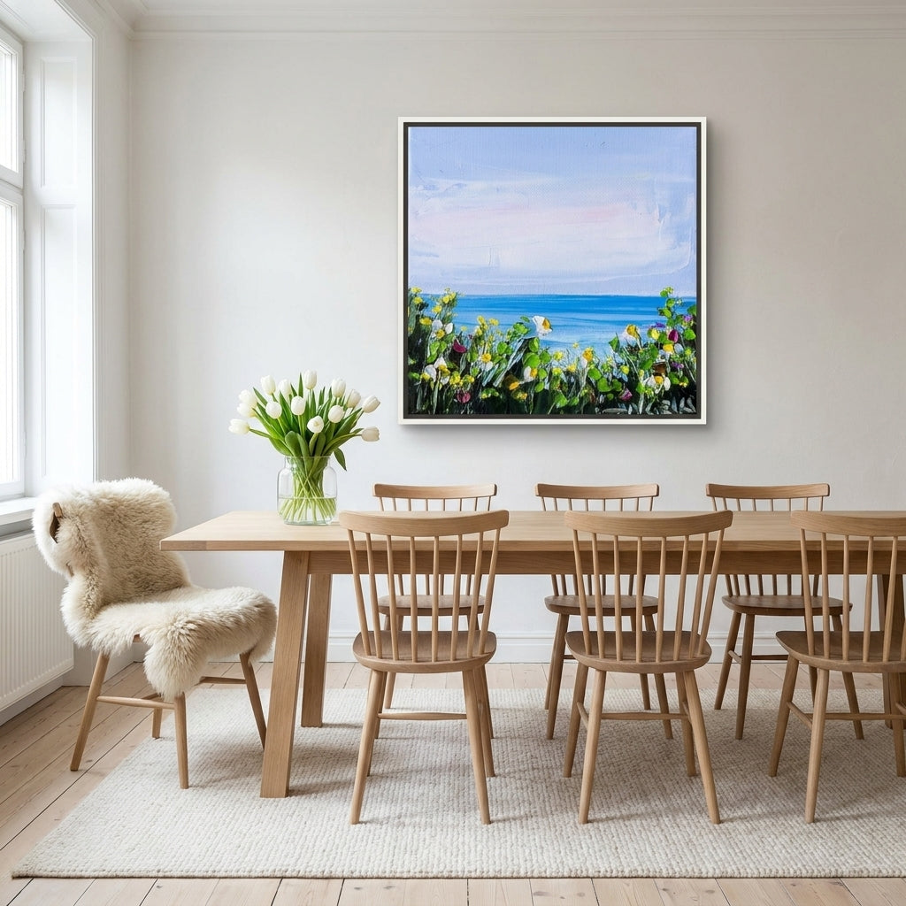 Canvas wall art with a white surround styled on the wall in a bright Scandinavian dining room