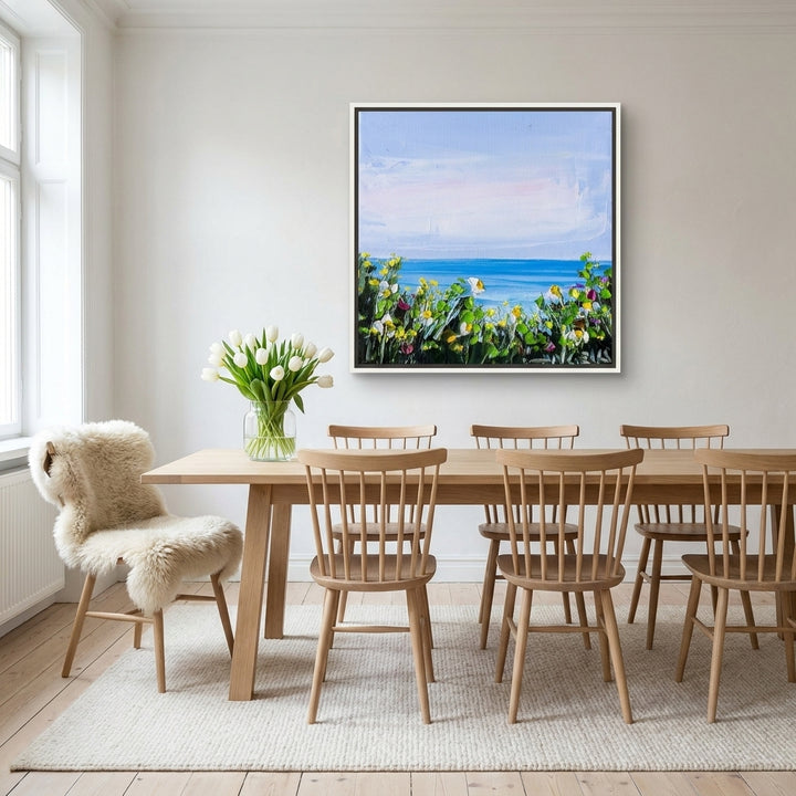Canvas wall art with a white surround styled on the wall in a bright Scandinavian dining room