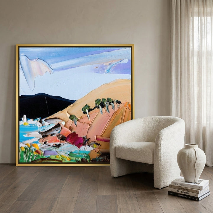 Oversized statement canvas wall art with a gold leaf surround leaning against the wall in a luxe living room