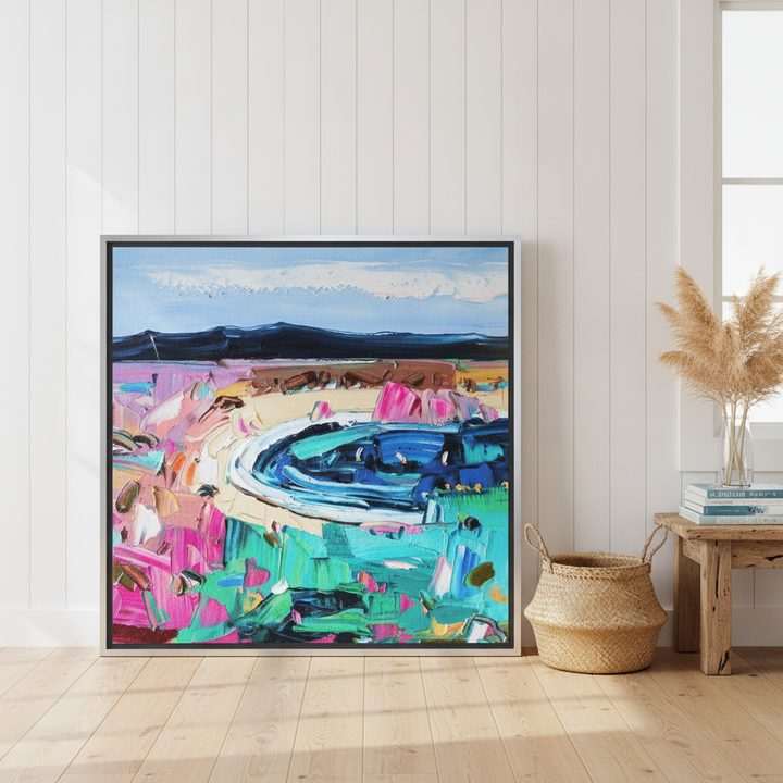 Canvas wall art with a silver leaf surround leaning against the wall in a coastal dining room