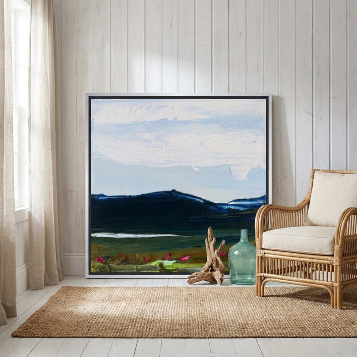 Canvas wall art with a silver leaf surround leaning against the wall in a coastal bedroom