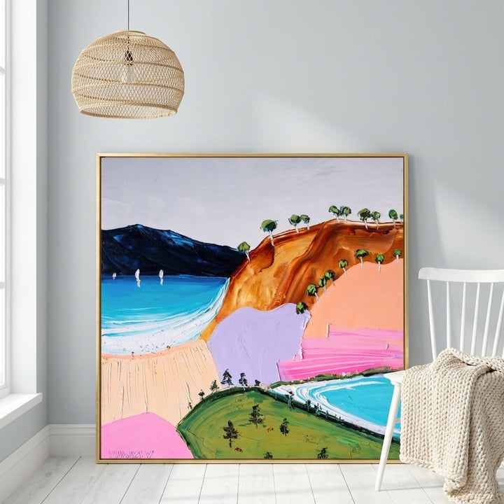 Canvas wall art with a gold leaf surround leaning against the wall in a bright Scandinavian bedroom