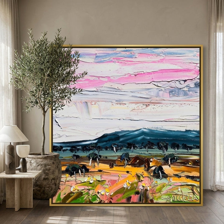 Oversized statement canvas wall art with a gold leaf surround leaning against the wall in a luxe bedroom