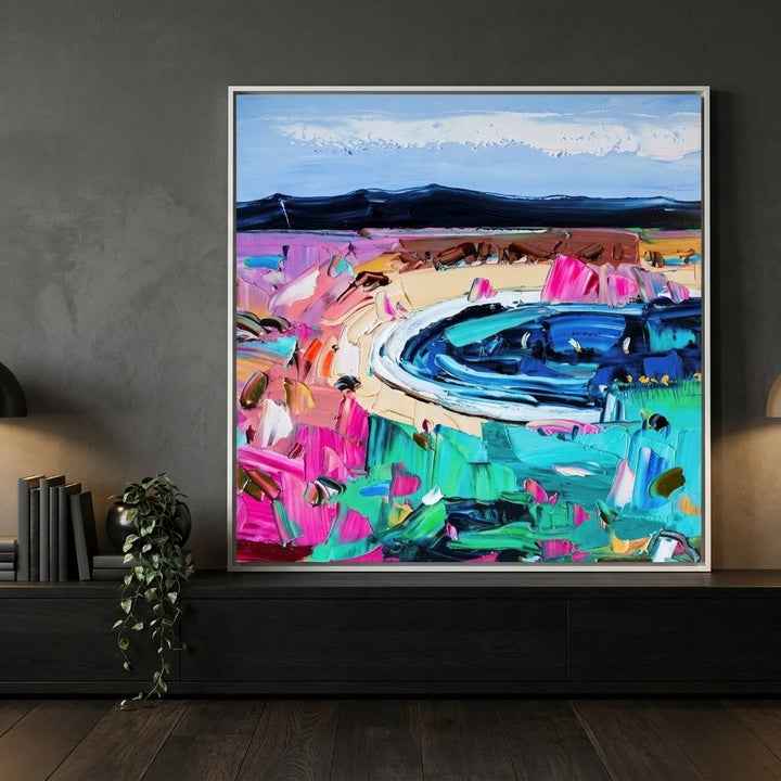 Canvas wall art with a white surround standing on a console in a moody home office