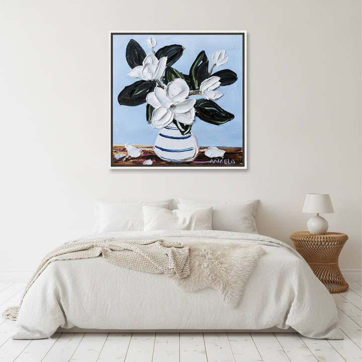 Canvas wall art with a white surround styled on the wall in a bright Scandinavian bedroom