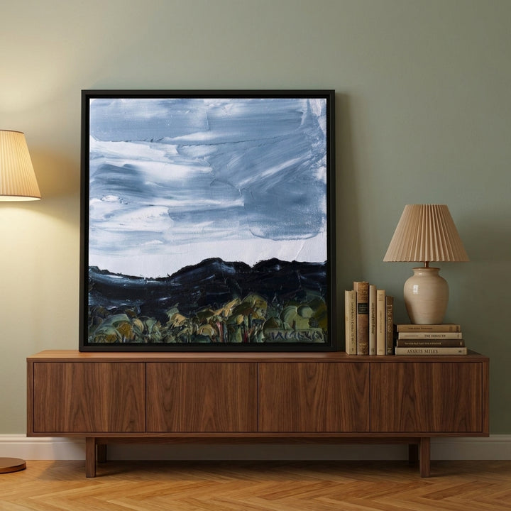 Canvas wall art with a black surround standing on a sideboard in a mid-century bedroom