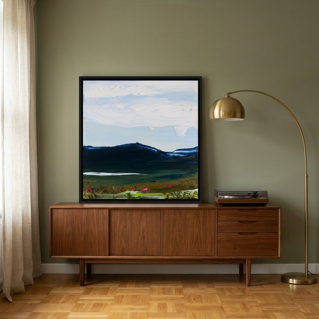 Canvas wall art with a black surround standing on a sideboard in a mid-century home office