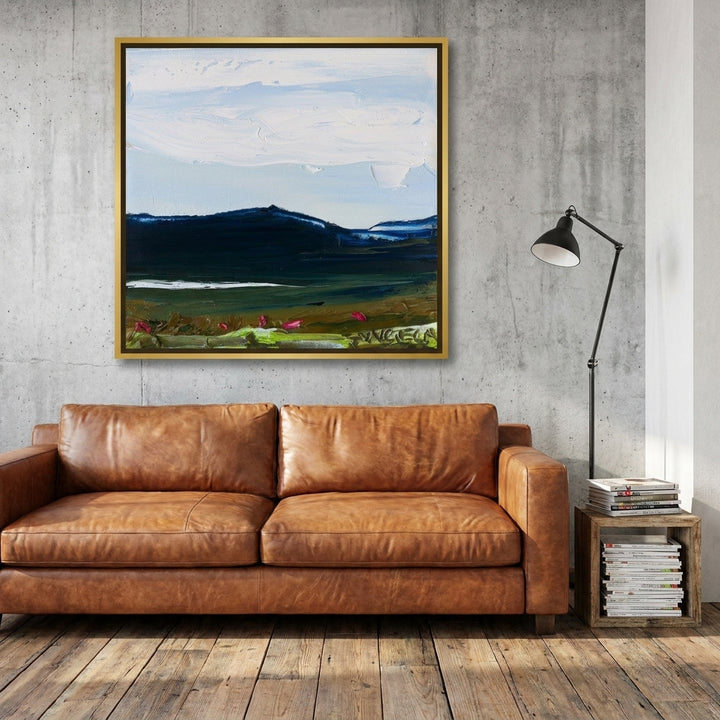 Canvas wall art with a gold leaf surround styled on the wall in an industrial loft living room