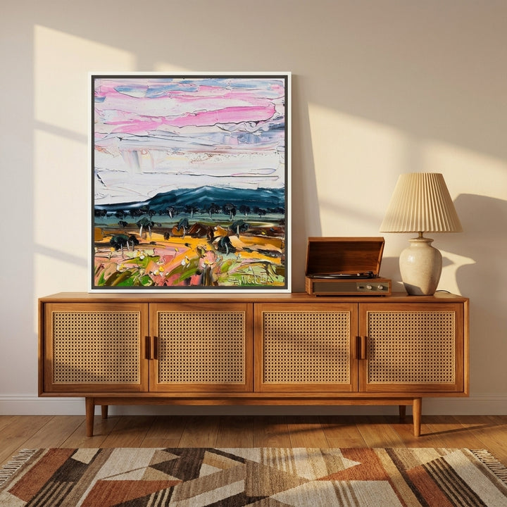 Canvas wall art with a white surround standing on a sideboard in a mid-century home office