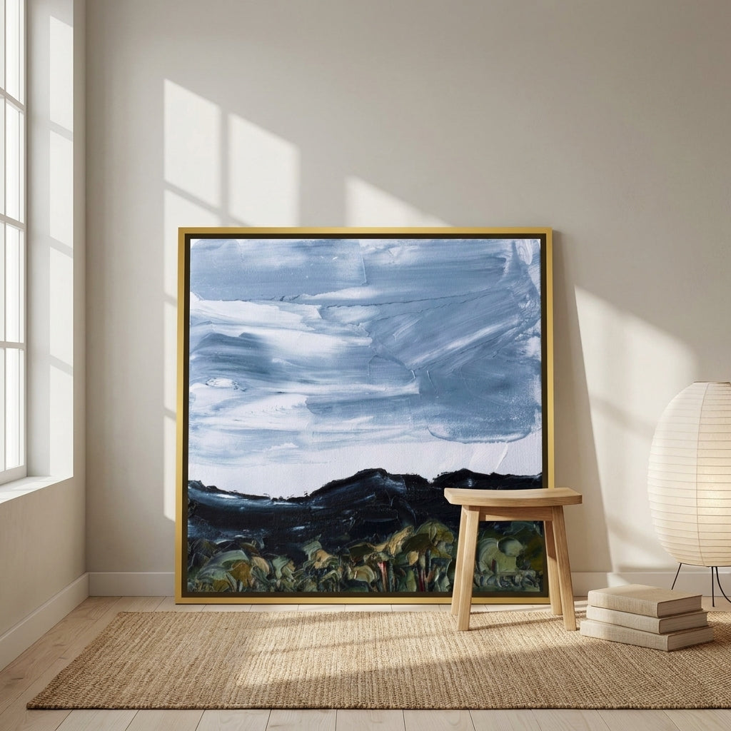 Canvas wall art with a gold leaf surround leaning against the wall in a warm Japandi living room