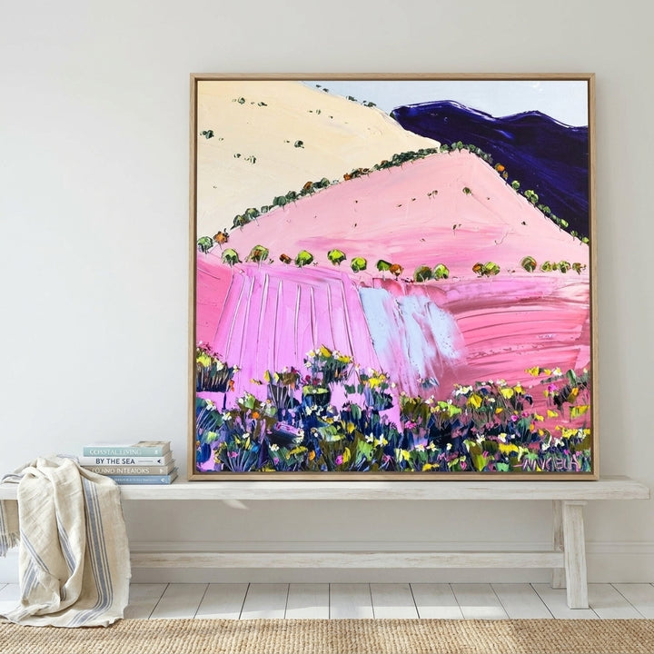 Canvas wall art with a natural timber surround standing on a console in a coastal bedroom
