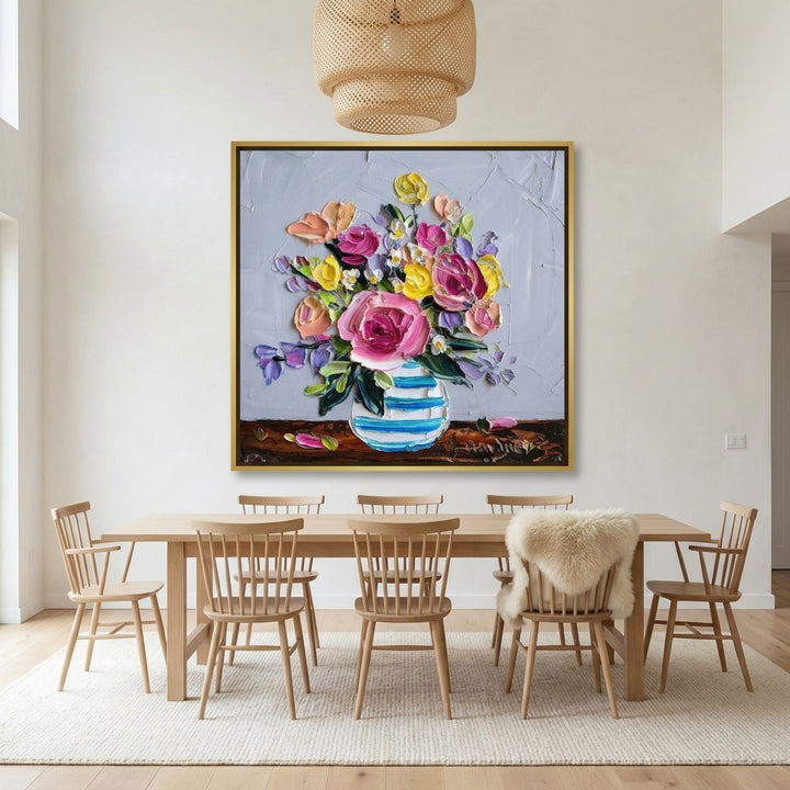 Oversized statement canvas wall art with a gold leaf surround styled on the wall in a bright Scandinavian dining room