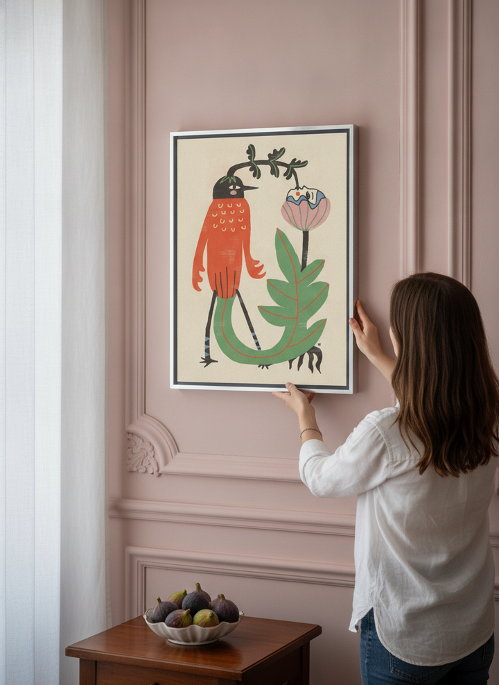 Person holding canvas wall art with a silver leaf surround in a Parisian living room
