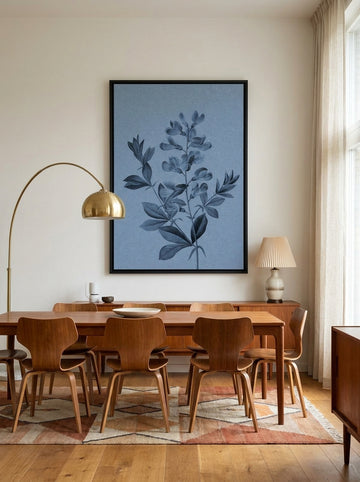 Oversized statement canvas wall art with a black surround styled on the wall in a mid-century dining room