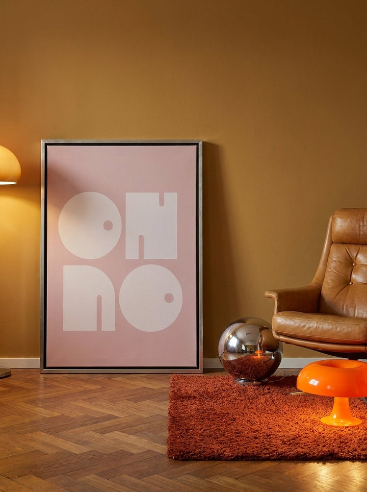 Canvas wall art with a silver leaf surround leaning against the wall in a retro 70s home office