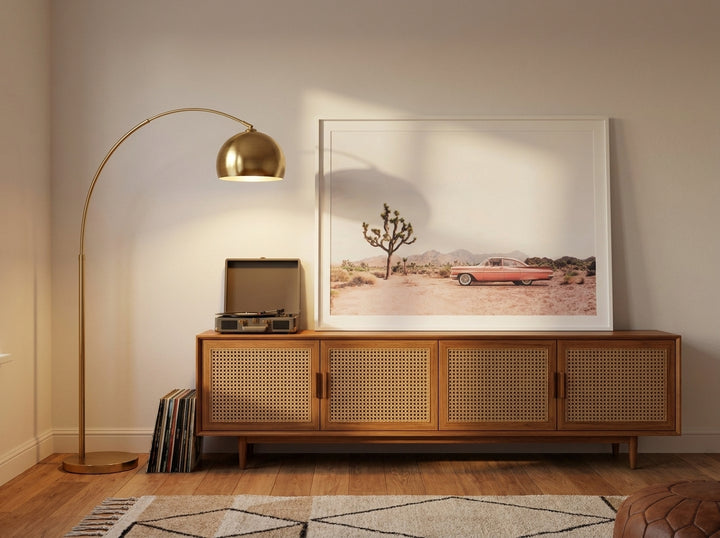 Modern wall art print standing on a sideboard in a mid-century bedroom