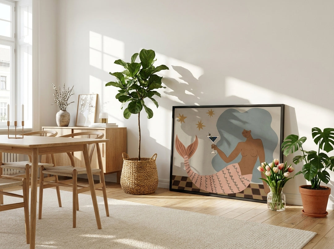 Canvas wall art with a black surround leaning against the wall in a bright Scandinavian dining room