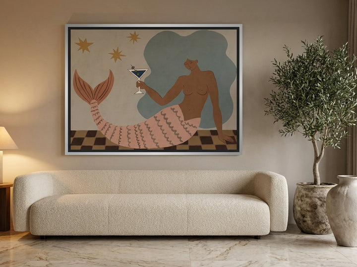 Oversized statement canvas wall art with a silver leaf surround styled on the wall in a luxe living room