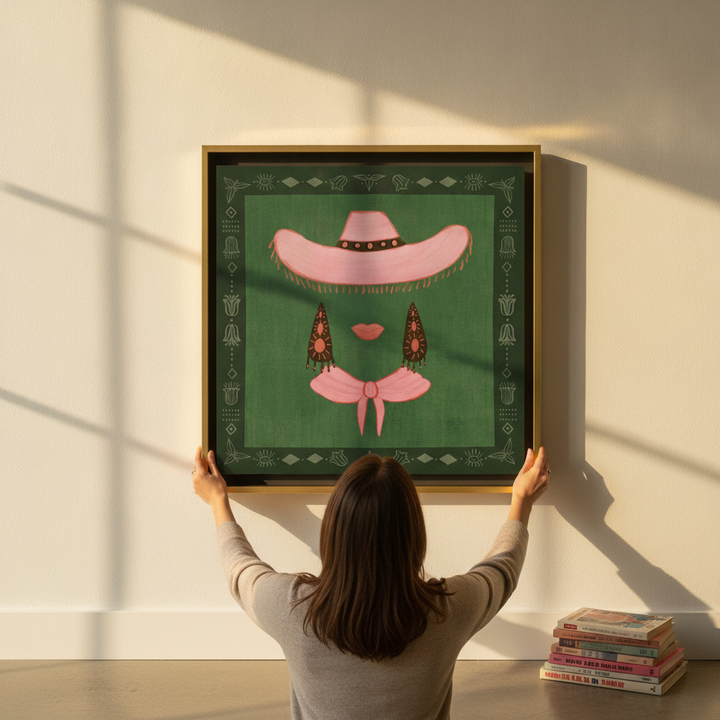 Person holding canvas wall art with a gold leaf surround in a mid-century living room