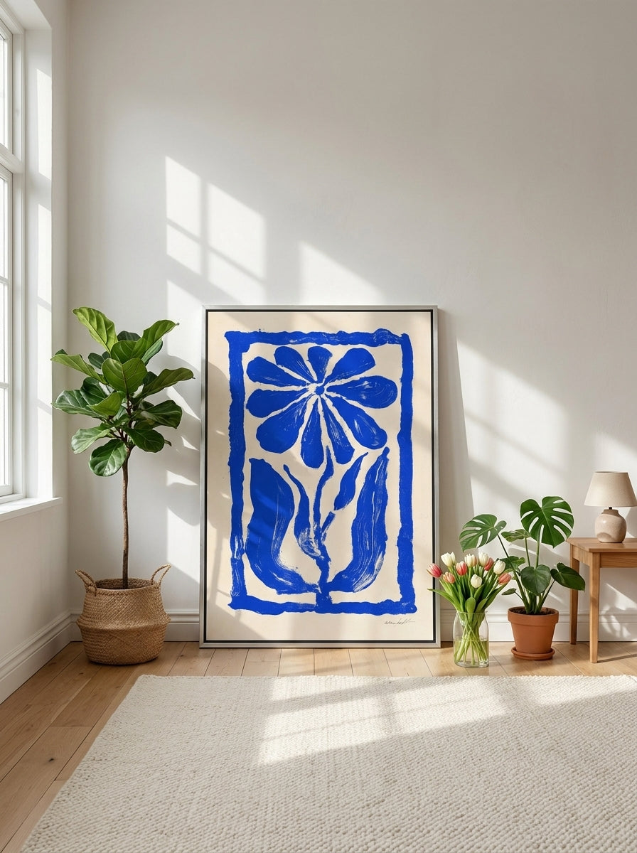 Canvas wall art with a silver leaf surround leaning against the wall in a bright Scandinavian bedroom